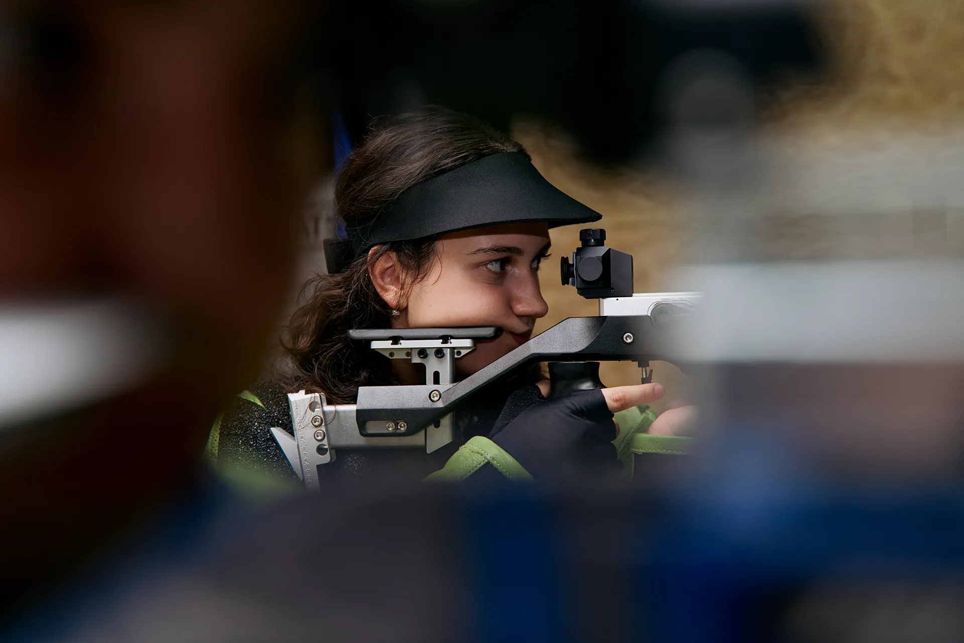 Eine Sportschützin visiert das Ziel mit ihrem Gewehr an