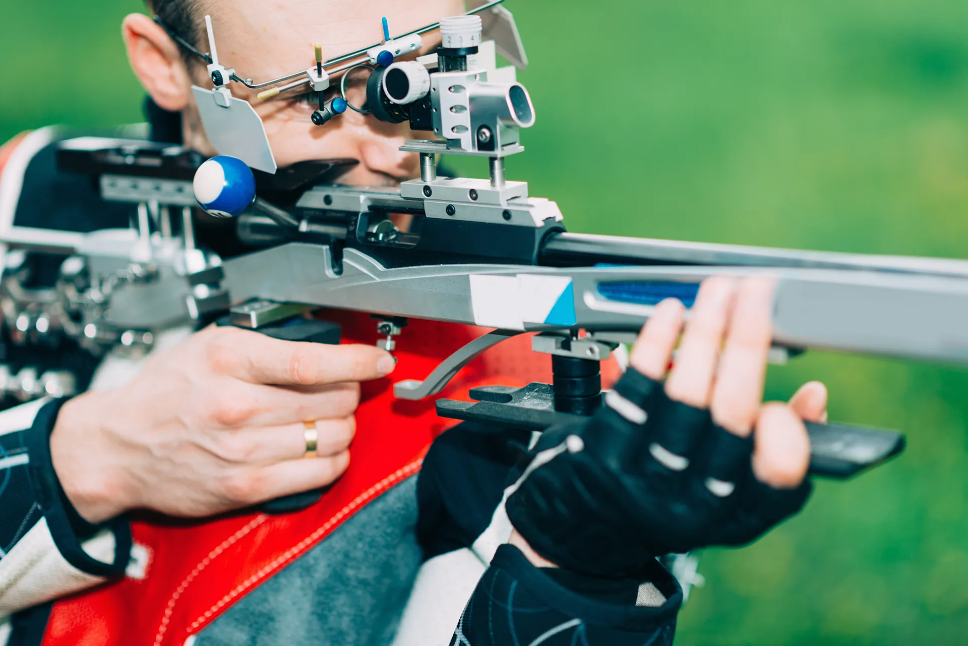 Nahaufnahme eines Sportschützen mit Gewehr beim Anvisieren seines Ziels